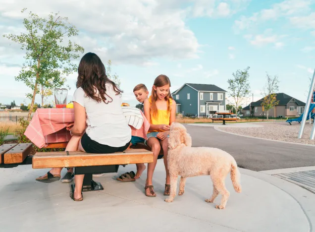 A family sititing on a bench with their dog